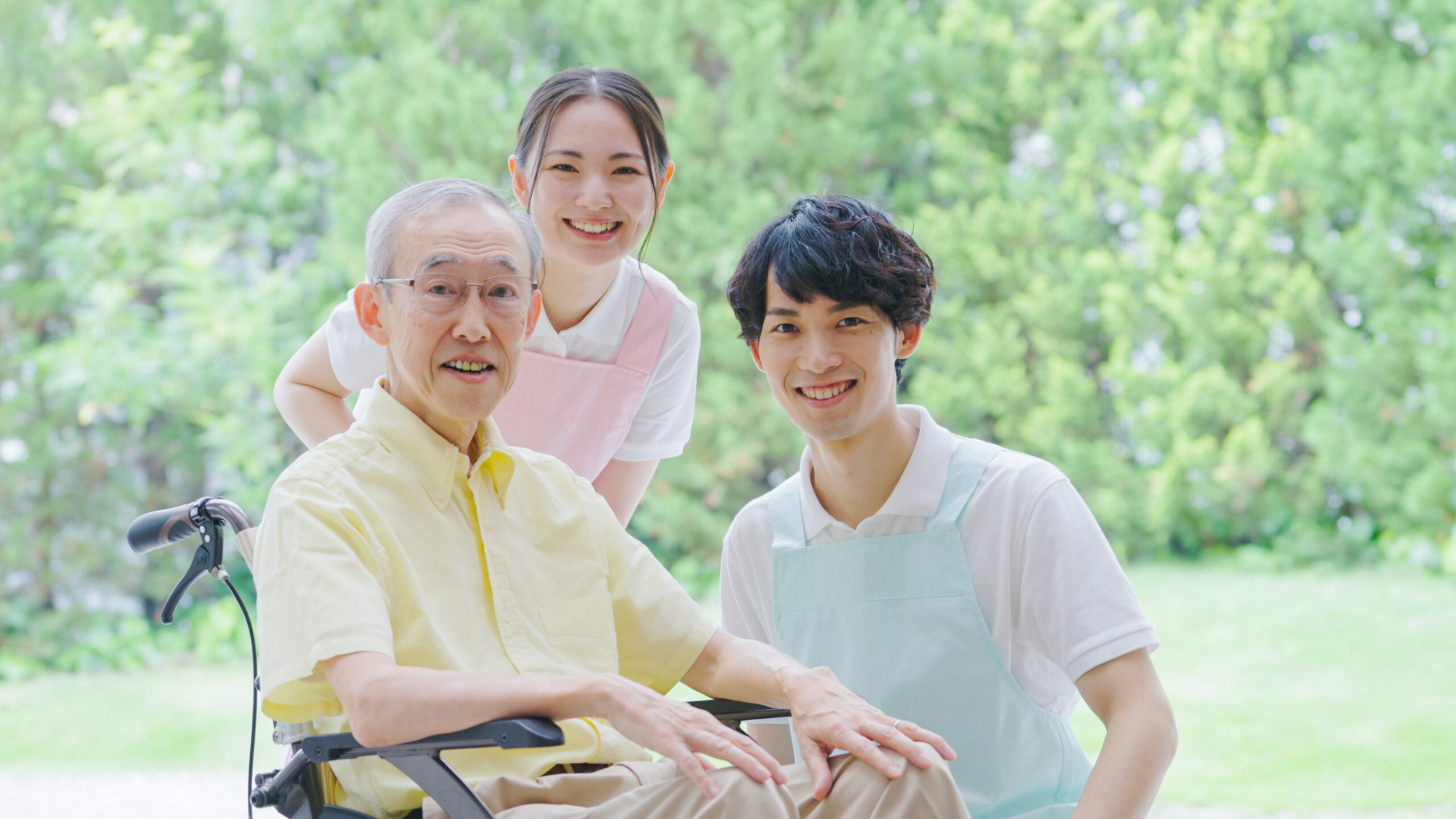 笑顔の介護士と車椅子の高齢者の写真